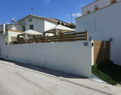 a white fence in front of a house at Elaida Home in Psathoyiánnos