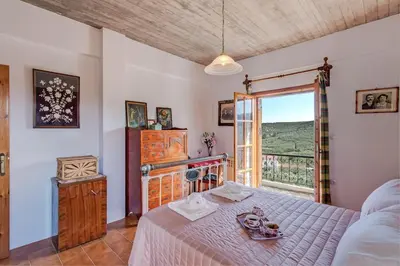 a bedroom with a bed and a large window at Lilly Traditional Cretan Villa in Dhrakóna