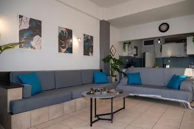 a living room with a blue couch and a table at Be Crete - Horizon in Chania Town