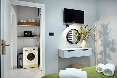 a bedroom with a washing machine and a tv at El Dorado Corner with Hot Tub in Chania Town