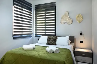 a bedroom with a green bed with towels on it at El Dorado Corner with Hot Tub in Chania Town