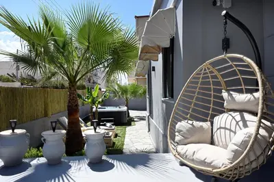 a wicker chair sitting on a table on a patio at El Dorado Corner with Hot Tub in Chania Town