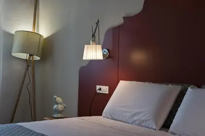 a bedroom with a bed with a red headboard and two lamps at Elia Zampeliou Hotel in Chania Town