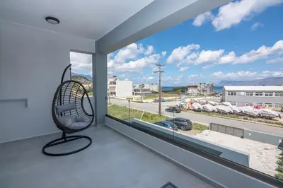 a room with a chair in front of a window at Gems - Stunning 2BR Apts - Steps from the Beach! in Kissamos