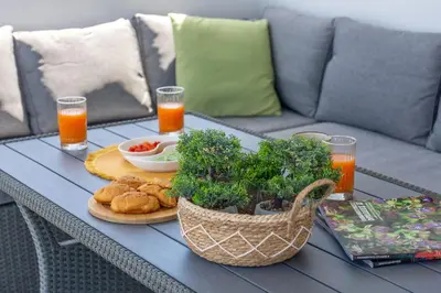 a table with a tray of food and orange juice at Gems - Stunning 2BR Apts - Steps from the Beach! in Kissamos