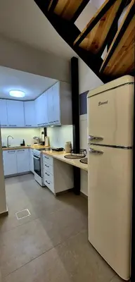 a kitchen with a white refrigerator in a room at Mposkini house - next to Chania town center in Chania Town