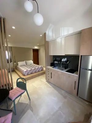 a bedroom with a bed and a kitchen with a refrigerator at Saxon's Corner in Chania Town