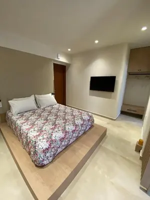 a bedroom with a large bed and a flat screen tv at Saxon's Corner in Chania Town
