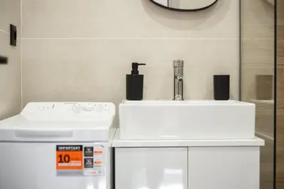 a bathroom with a sink and a washing machine at Nektaria Studio in Chania Town