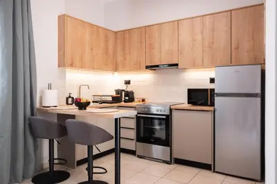 a kitchen with stainless steel appliances and wooden cabinets at Nektaria Studio in Chania Town