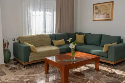 a living room with a green couch and a coffee table at Lumea Apartment in Chania Town