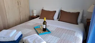 a bed with a bottle of wine and glasses on it at Villa Agassi Aspo Apokoronas Crete in Koprána