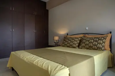 a bedroom with a large bed with brown cabinets at Chania Garden Retreat in Souda