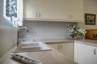 a kitchen with a sink and a vase of flowers at Chania Garden Retreat in Souda