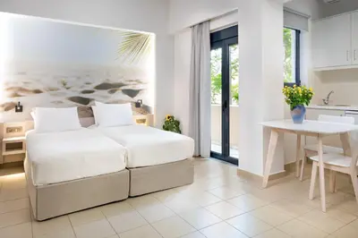 a bedroom with a bed and a table and a kitchen at Forum City Apartments in Chania Town