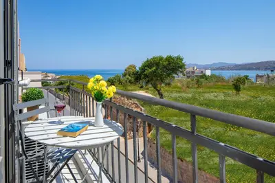 a table on a balcony with a view of the ocean at Forum City Apartments in Chania Town