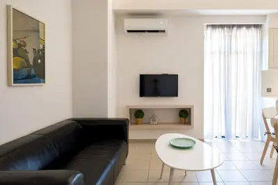 a living room with a black leather couch and a table at Forum City Apartments in Chania Town