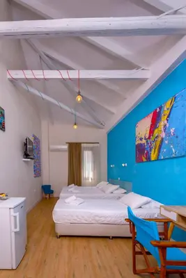 a bedroom with a bed and a blue wall at TheJoy in Chania Town