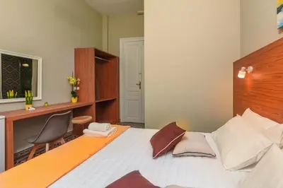 a bedroom with a bed with a desk and a chair at TheJoy in Chania Town