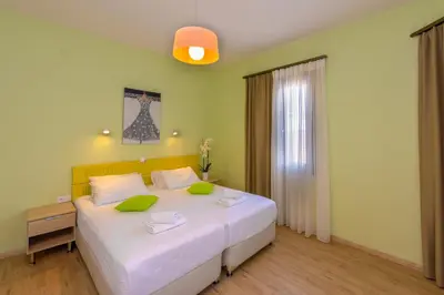 a bedroom with a large white bed with green pillows at TheJoy in Chania Town
