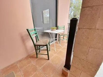 a room with chairs and a table and a table at Green door in Nerokoúros
