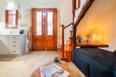 a living room with a couch and a wooden door at Maisonette in center of Chania with roofgarden! in Chania Town