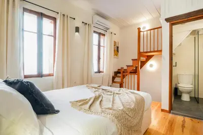 a bedroom with a white bed and a staircase at Maisonette in center of Chania with roofgarden! in Chania Town
