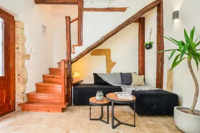 a living room with a black couch and stairs at Maisonette in center of Chania with roofgarden! in Chania Town