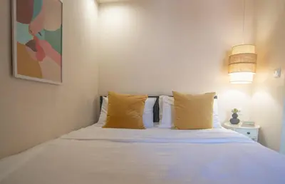 a white bed with yellow pillows in a bedroom at Central old Town house with jacuzzi and yard,4ppl in Chania Town