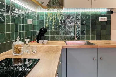 a kitchen with a sink and green tiled wall at Central old Town house with jacuzzi and yard,4ppl in Chania Town