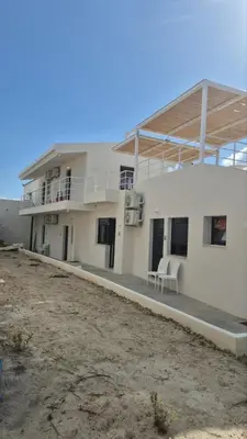 a large white building with a porch and a balcony at Aldea Apartments in Palio Gerani