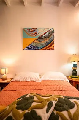 a bedroom with a bed with a painting on the wall at Romantic Maisonette in Chania Town