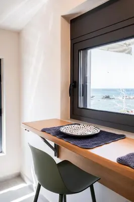 a table with a chair and a television on a desk at Paradise for Couples, Next to Soothing Waves in Galatás