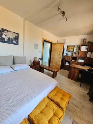 a bedroom with a large white bed and a desk at Cozy Room wtih Amazing Sea View of the Old Harbour in Chania Town