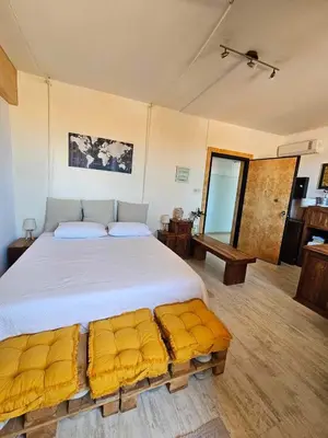 a bedroom with a large bed with yellow cushions at Cozy Room wtih Amazing Sea View of the Old Harbour in Chania Town