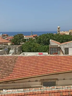 a group of roofs with the ocean in the background at Cozy Room wtih Amazing Sea View of the Old Harbour in Chania Town