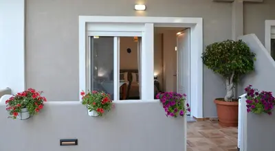 two potted plants on a white wall with flowers at Tile apartments 1 in Agia Marina Nea Kydonias