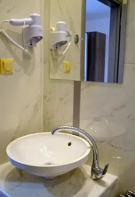 a white sink in a bathroom with a mirror at Tile apartments 1 in Agia Marina Nea Kydonias