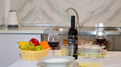 a table with two glasses of wine and a basket of fruit at Tile apartments 1 in Agia Marina Nea Kydonias