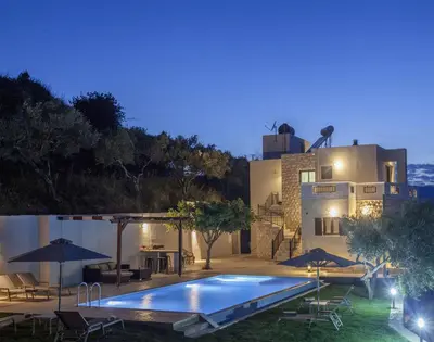 a swimming pool in front of a house at night at Villa Veghera in Kissamos