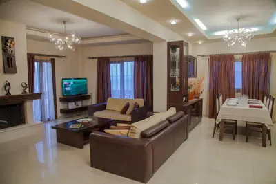 a living room with a couch and a table and a television at Villa Veghera in Kissamos