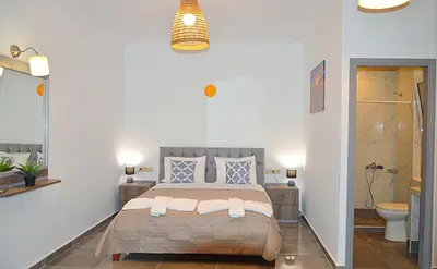 a bedroom with a large bed and a bathroom at Tile Apartments 2 in Agia Marina Nea Kydonias