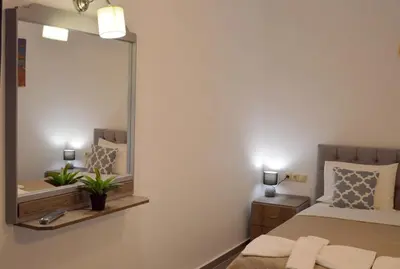 a bedroom with a large mirror and a bed at Tile Apartments 2 in Agia Marina Nea Kydonias