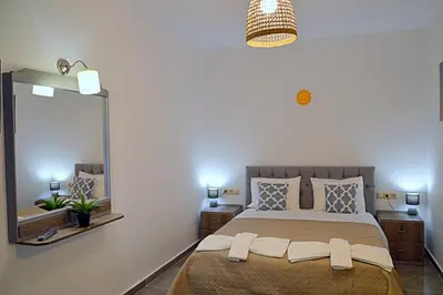 a bedroom with a large bed with a large mirror at Tile Apartments 2 in Agia Marina Nea Kydonias