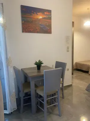 a dining room table and chairs with a painting on the wall at Tile Apartments 3 in Agia Marina Nea Kydonias