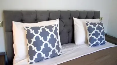 a bed with three pillows on top of it at Tile Apartments 3 in Agia Marina Nea Kydonias