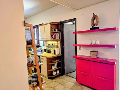 a kitchen with red shelves and a red cabinet at Zen House with Fairytale Garden & Sea View in Daratso