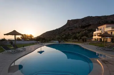 a large swimming pool with a mountain in the background at Libyan Mare in Palaiochóra