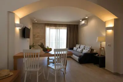 a living room with a table and chairs and a couch at Libyan Mare in Palaiochóra