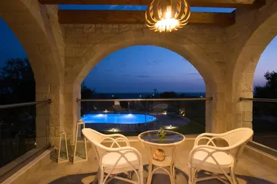 a patio with a table and chairs and a pool at Libyan Mare in Palaiochóra